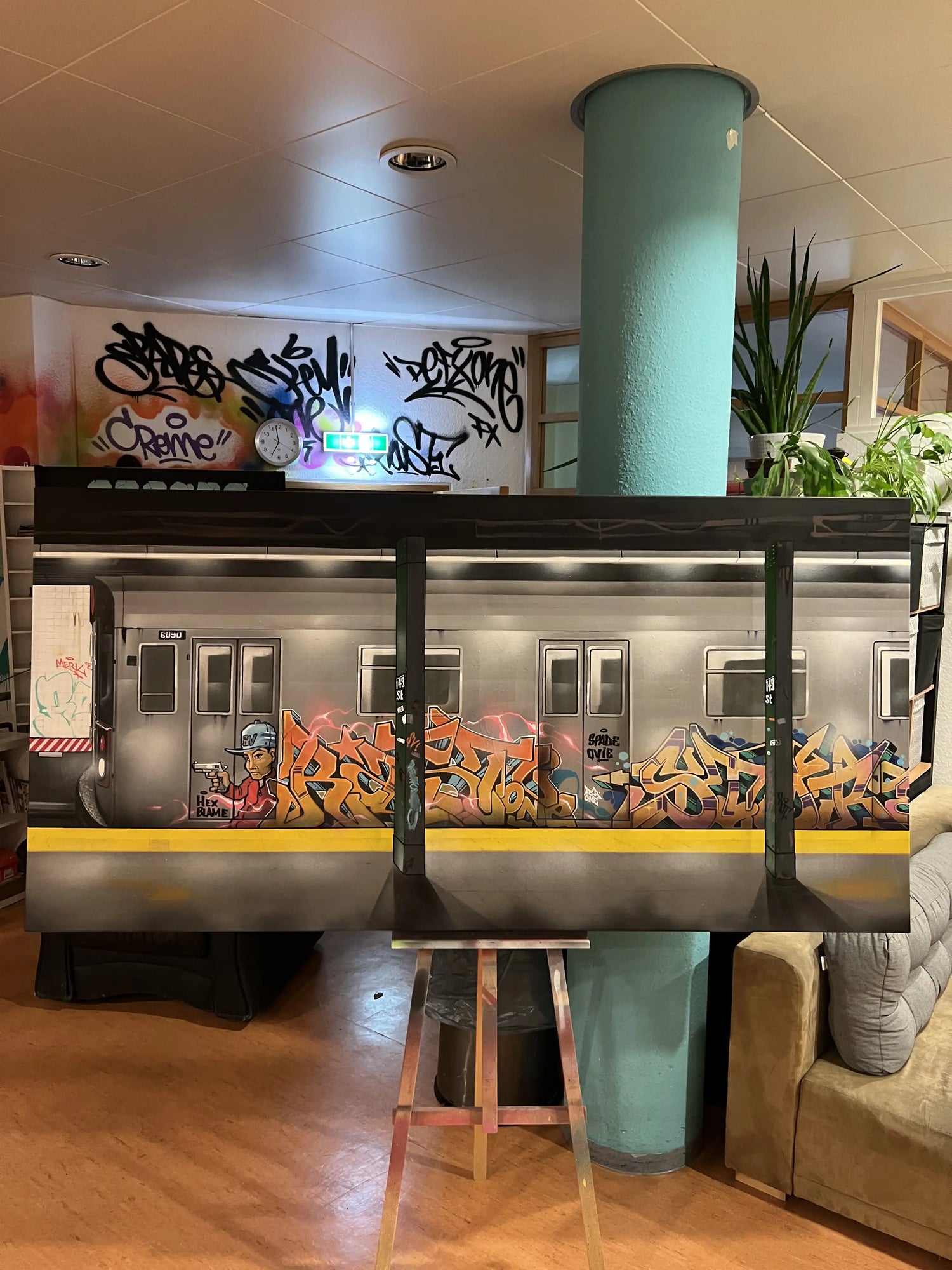 Graffiti-Wandgestaltung im Innenraum mit U-Bahn-Motiv, urbaner Street-Art und bunten Graffiti-Elementen